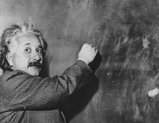 Albert Einstein writing on a chalkboard