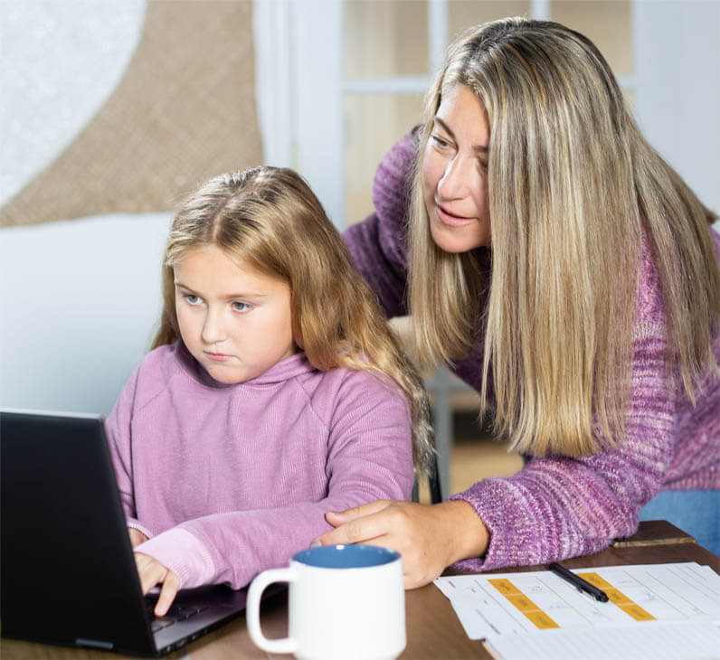 mom and daughter looking at the computer together